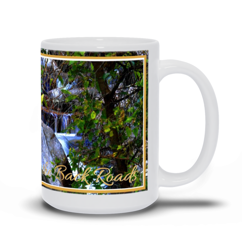 A white ceramic mug with a scenic photograph of South Boulder Creek through the trees, and the text 'Back Roads' printed on it.