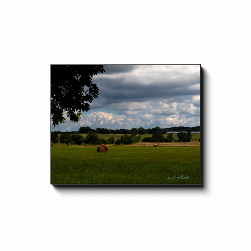 Gallery-wrapped canvas print featuring a rural Arkansas hayfield with round bales beneath a dramatic cloudy sky.