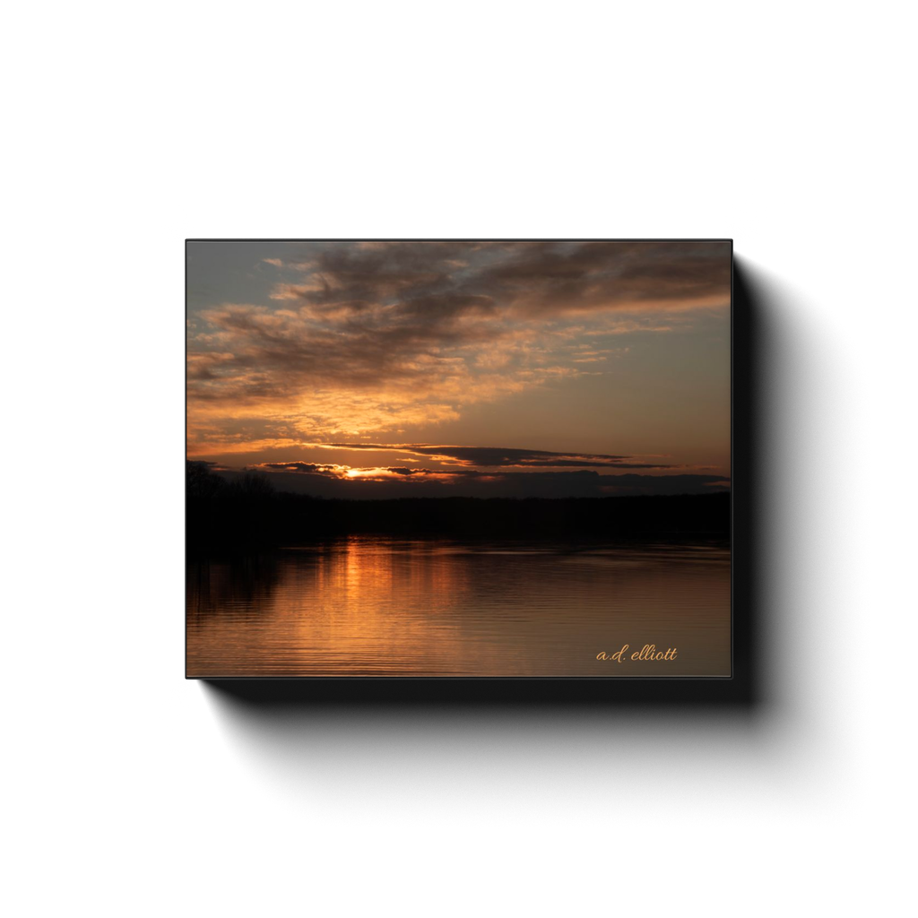 Gallery-wrapped canvas print featuring a glowing sunset over Loch Lomond with dark clouds and golden reflections on the water.