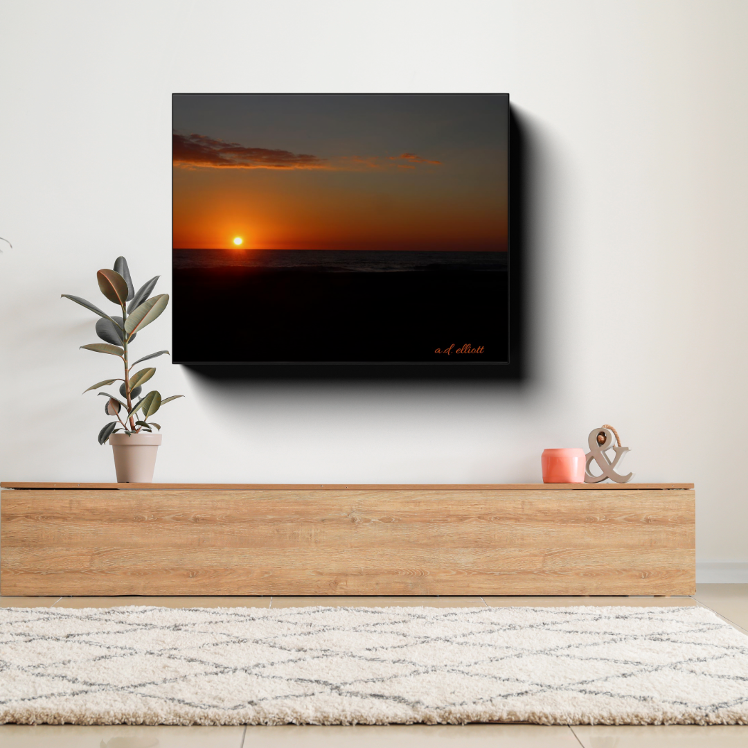 Gallery-wrapped canvas featuring an October sunrise over Virginia Beach displayed above a wooden console table in a bright contemporary living room.