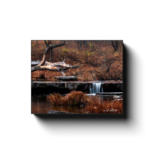 Gallery-wrapped canvas print featuring a small waterfall, driftwood, still water, and warm autumn tones in Osage Hills State Park, Oklahoma.