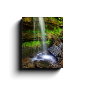 Gallery-wrapped canvas print featuring a soft waterfall, wet rocks, and lush green vegetation at Devil’s Den State Park in Arkansas.
