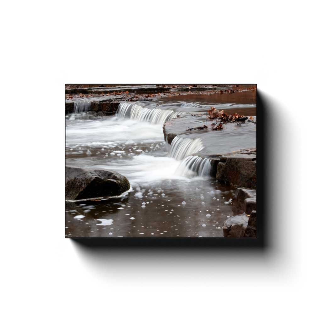 A long exposure photograph of a cascade on Sand Creek in Osage Hills State Park Oklahoma. Taken by the photographer a.d. elliott - Take the Back Roads - #TaketheBackRoads  Printed on high quality, artist-grade stock and folded around a lightweight frame to give them a gorgeous, gallery-ready appearance. With acid-free ink that will last without fading or chipping, Features a scratch-resistant UV coating. Wipes clean easily with a damp cloth or to remove dust, vacuum gently using a soft brush attachment.