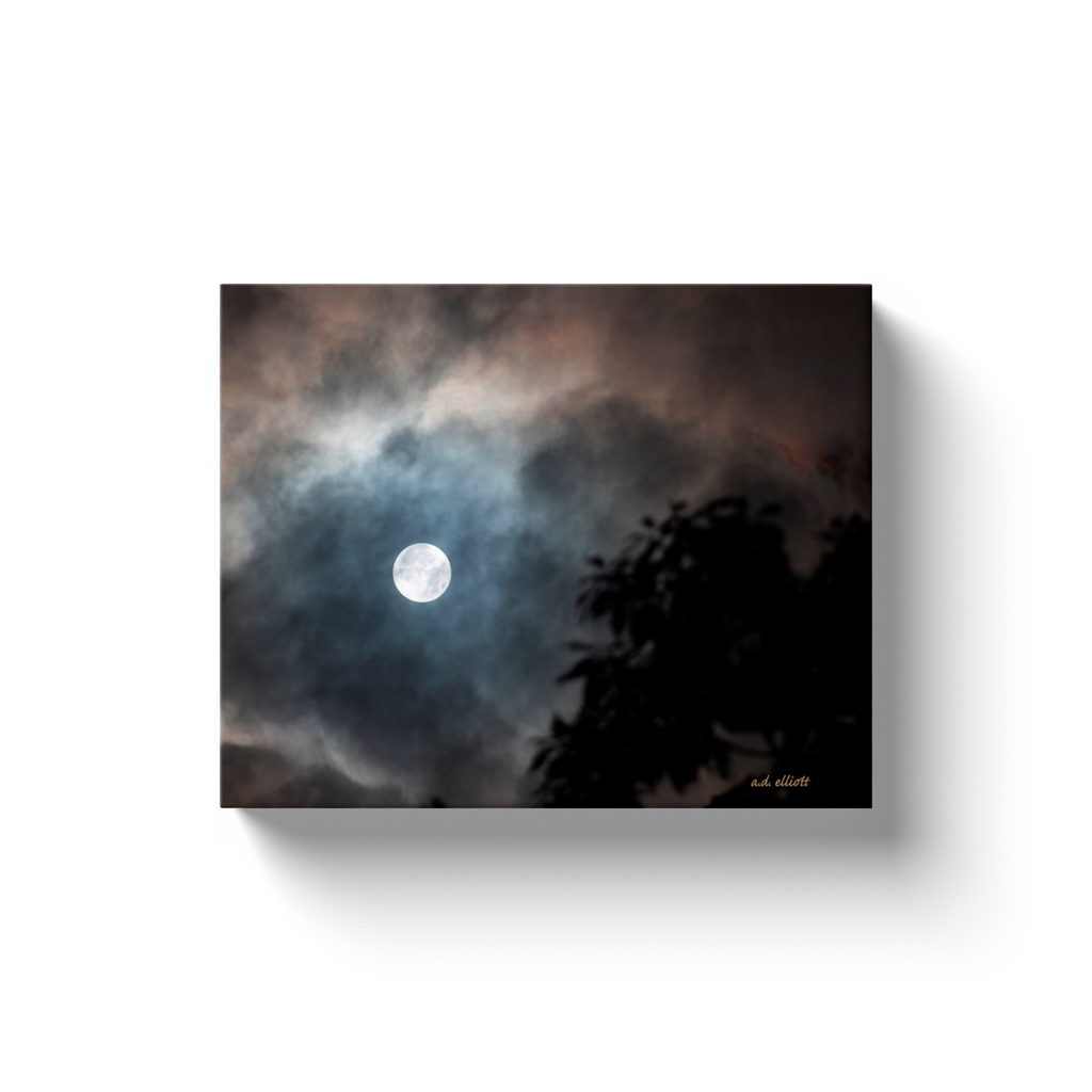 A landscape photograph of a full moon through clouds. Taken by the Arkansas a.d. elliott.  Printed on high quality, artist grade stock and folded around a lightweight frame to give them a gorgeous, gallery ready appearance. With acid free ink that will last without fading or chipping, Features a scratch-resistant UV coating. Wipes clean easily with a damp cloth or to remove dust, vacuum gently using a soft brush attachment.