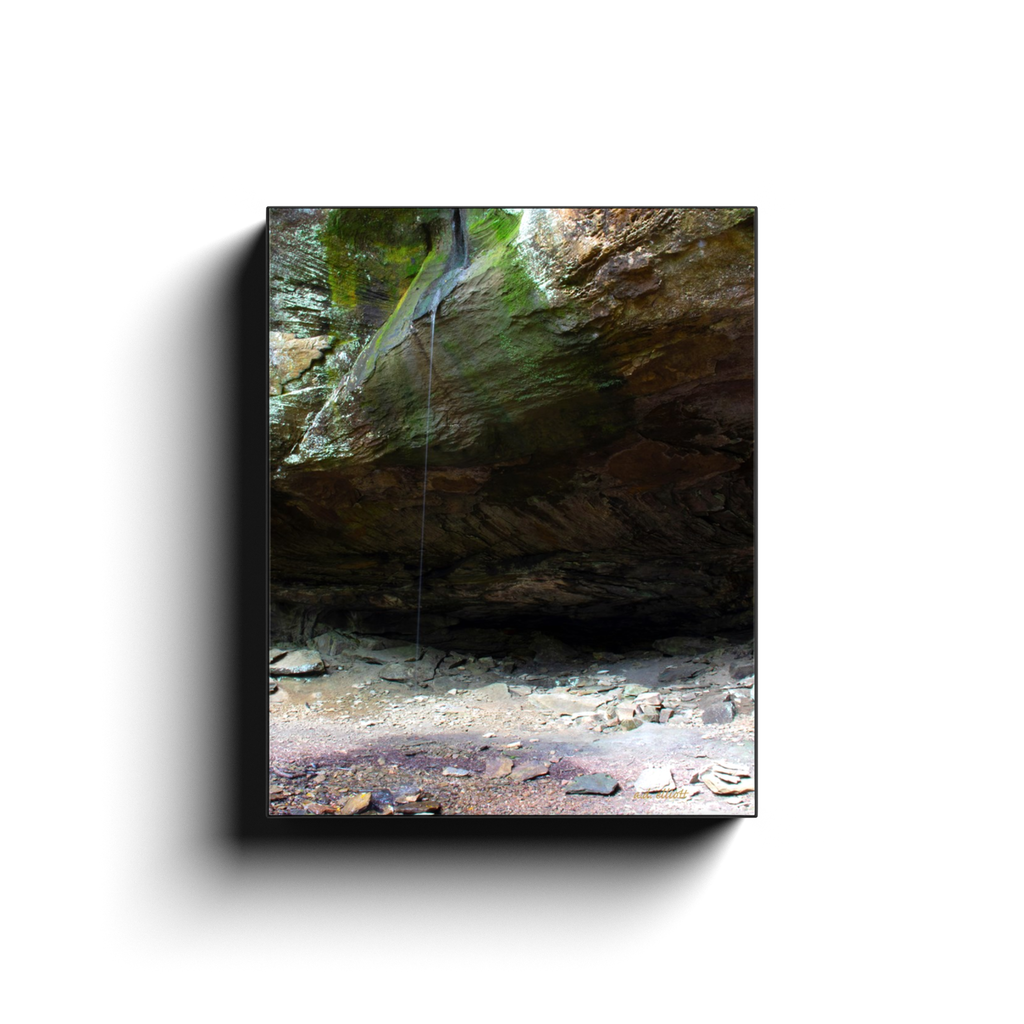 A long exposure photograph of a trickle of water over a bluff, taken at Pam's Grotto Arkansas by the photographer a.d. elliott  Printed on high quality, artist grade stock and folded around a lightweight frame to give them a gorgeous, gallery ready appearance. With acid free ink that will last without fading or chipping, Features a scratch-resistant UV coating. Wipes clean easily with a damp cloth or to remove dust, vacuum gently using a soft brush attachment.