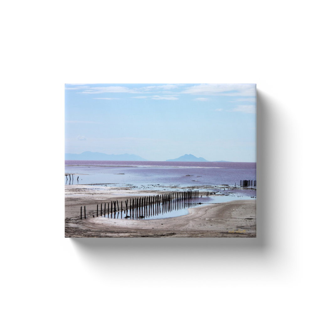 A landscape photograph of pier remains on the Great Salt Lake near Rozel Point. Taken by the Arkansas photographer a.d. elliott.  Printed on high quality, artist-grade stock and folded around a lightweight frame to give them a gorgeous, gallery-ready appearance. With acid-free ink that will last without fading or chipping, Features a scratch-resistant UV coating. Wipes clean easily with a damp cloth or to remove dust, vacuum gently using a soft brush attachment.