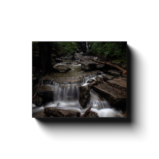 A long exposure photograph of a cascade at the base of Norwood Falls, Bella Vista Arkansas. Taken by the photographer a.d. elliott - Take the Back Roads #TaketheBackRoads  Printed on high quality, artist-grade stock and folded around a lightweight frame to give them a gorgeous, gallery-ready appearance. With acid free ink that will last without fading or chipping, Features a scratch-resistant UV coating. Wipes clean easily with a damp cloth or to remove dust, vacuum gently using a soft brush attachment.
