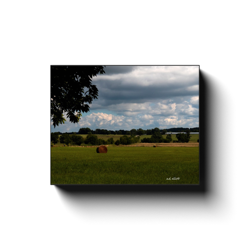 Landscape photography of hay bales in a field. Taken by the photographer a.d. elliott.  Printed on high quality, artist-grade stock and folded around a lightweight frame to give them a gorgeous, gallery-ready appearance. With acid-free ink that will last without fading or chipping, Features a scratch-resistant UV coating. Wipes clean easily with a damp cloth or to remove dust, vacuum gently using a soft brush attachment.
